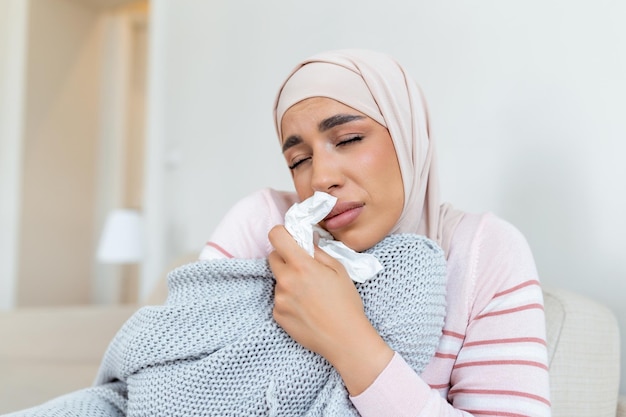 Concepto de problema de virus estacional de enfermedad Mujer árabe enferma con gripe acostada en la cama Mujer enferma con hiyab acostada en la cama con fiebre alta Gripe fría coronavirus covid19