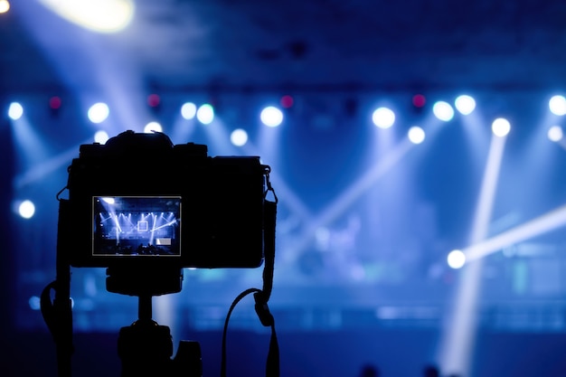 Concepto de producción en pubs y conciertos, cámara que dispara rayos de focos y luces en tonos azules.