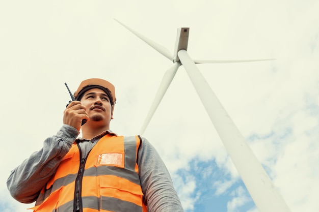 Concepto progresivo de ingeniero que trabaja en el parque eólico en la cima de la montaña