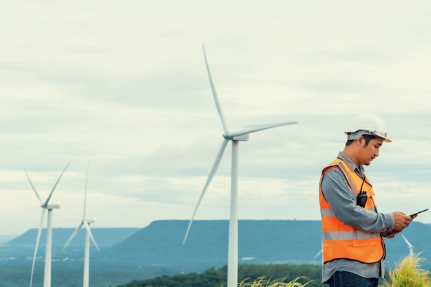 Concepto progresivo de ingeniero que trabaja en el parque eólico en la cima de la montaña