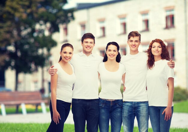 concepto de publicidad, amistad, educación, escuela y personas - grupo de adolescentes sonrientes con camisetas blancas en blanco sobre el fondo del campus