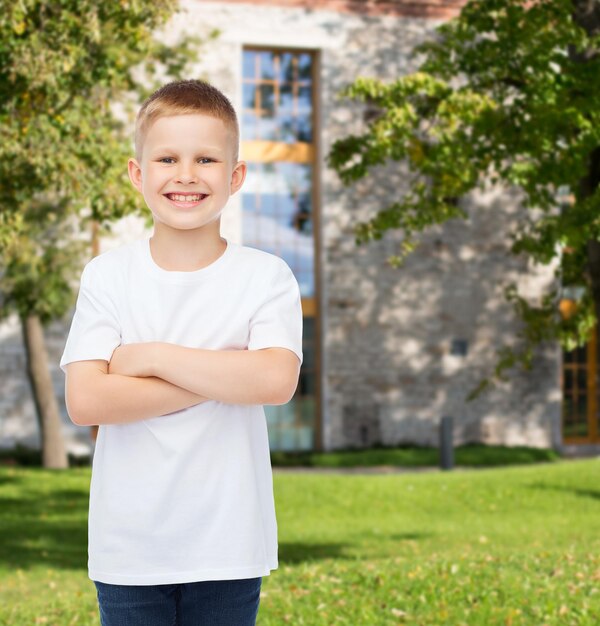 concepto de publicidad, verano, ocio, gente e infancia - niño sonriente con camiseta blanca en blanco sobre el fondo del campus