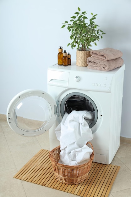 Concepto de quehaceres domésticos con lavadora contra la pared blanca