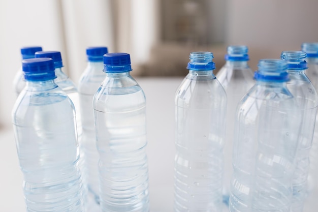 concepto de reciclaje, alimentación saludable y almacenamiento de alimentos: cierre de botellas de plástico con agua potable pura en la mesa