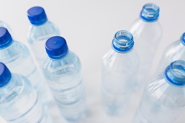 concepto de reciclaje, alimentación saludable y almacenamiento de alimentos: cierre de botellas de plástico con agua potable pura en la mesa