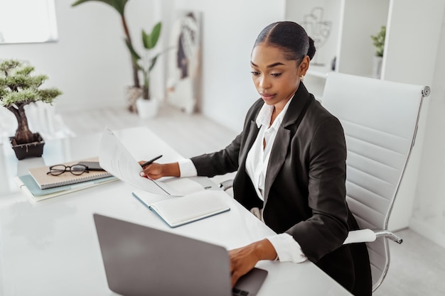 Concepto de reclutamiento profesional gerente de recursos humanos femenina negra usando una computadora portátil con currículum vitae de candidatos