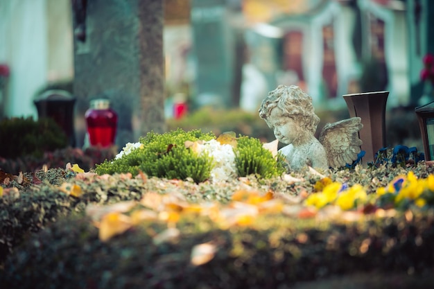 Foto concepto de recuerdo ángel blanco en una tumba flores