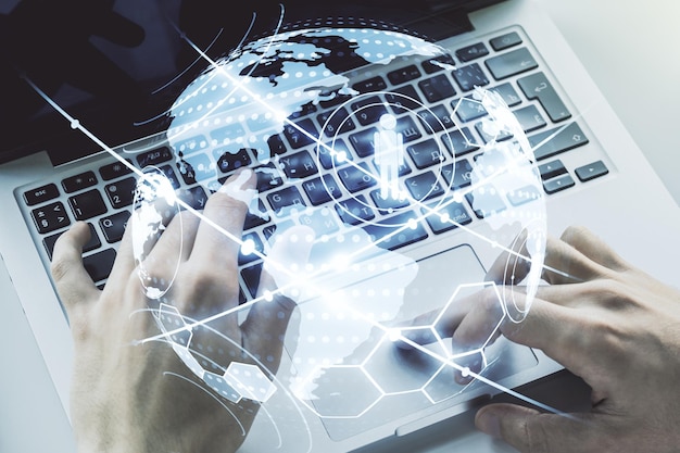 Concepto de red social con mapa del mundo y manos escribiendo en la computadora portátil en el fondo