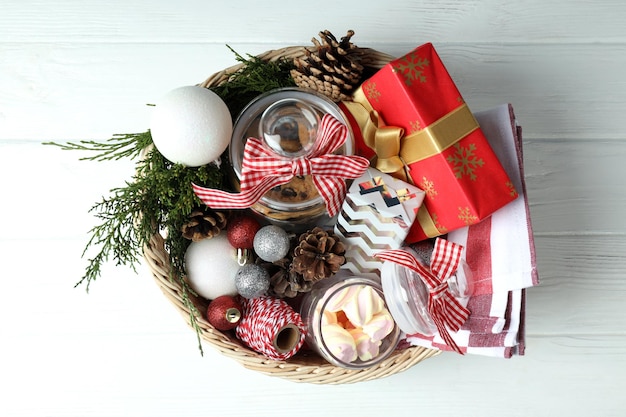 Concepto de regalo con canasta de Navidad en mesa de madera blanca