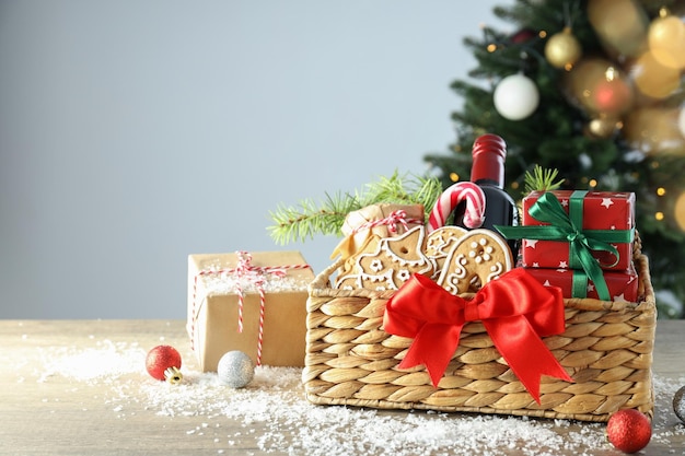 Concepto de regalo con canasta de Navidad en mesa de madera blanca