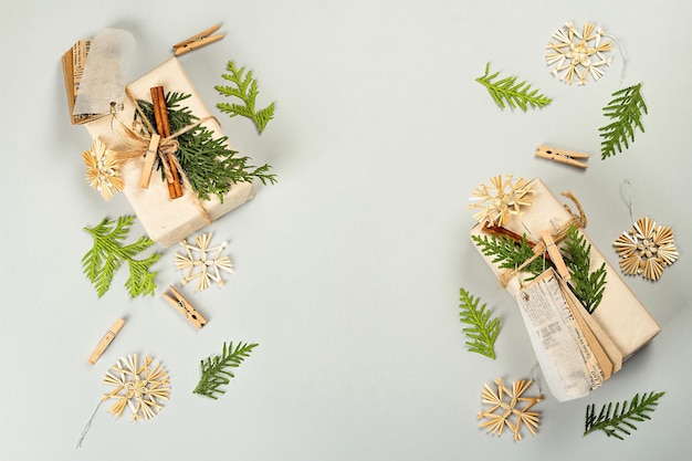 Concepto de regalo sin desperdicio. Embalaje ecológico de Navidad o Año Nuevo. Cajas festivas en papel artesanal con diferentes decoraciones orgánicas. Fondo gris claro, endecha plana, vista superior