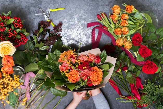 El concepto de regalos y ramos de flores para el 8 de marzo y el Día de la Madre. Floristería crea un ramo en una florería