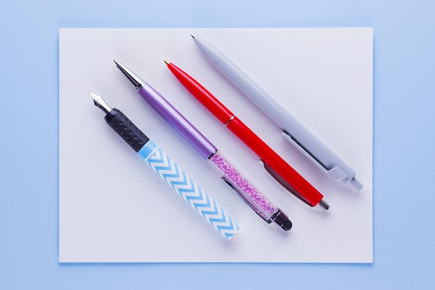 Concepto de regreso a la escuela Papelería escolar en fondo rosa azul Bolígrafos multicolores