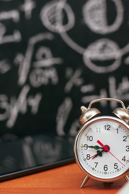 Concepto de regreso a la escuela, reloj despertador en la junta escolar, universidad, colegio