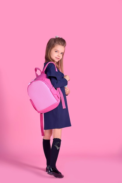 Concepto de regreso a la escuela Retrato de la foto de la mitad de la vuelta de la encantadora chica inteligente hermosa confiada con cuaderno de cuadernos vistiendo uniforme escolar vestido rosa brillante mochila aislado