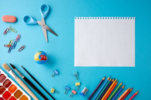 Concepto de regreso a la escuela sobre fondo de papel de textura azul