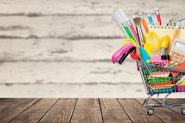 Foto concepto de regreso a la escuela, útiles escolares en el carrito de compras.