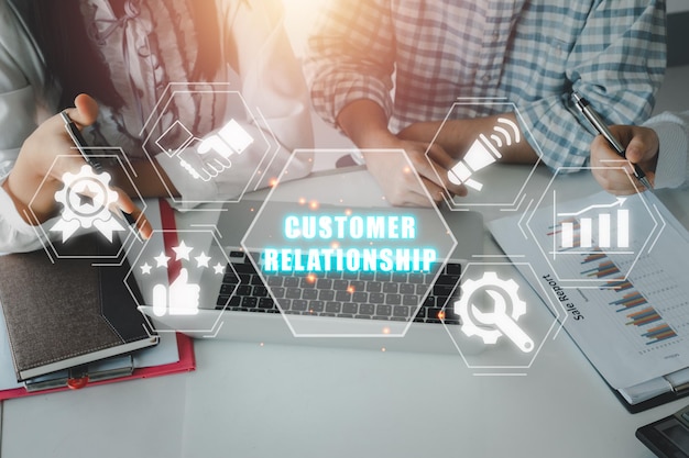 Concepto de relación con el cliente Equipo de negocios analizando gráficos y gráficos de ingresos en el escritorio de la oficina con el icono de relación con los clientes en la pantalla virtual