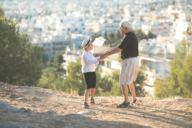 Concepto de relaciones y generación familiar de ancianos y jóvenes Abuelo y nieto jubilados jugando con el día soleado disfrutando al aire libre