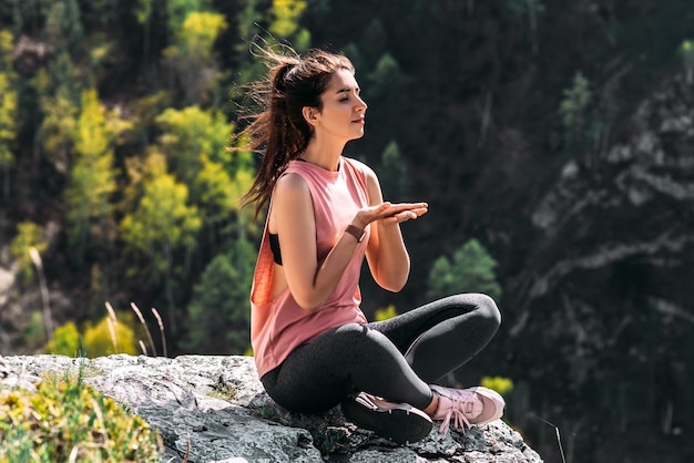 Concepto de relajación y estilo de vida saludable. Yoga al aire libre. Mujer feliz haciendo ejercicios de yoga. Meditación y relajación. Una mujer practicando yoga en la montaña. Una mujer medita en la naturaleza.