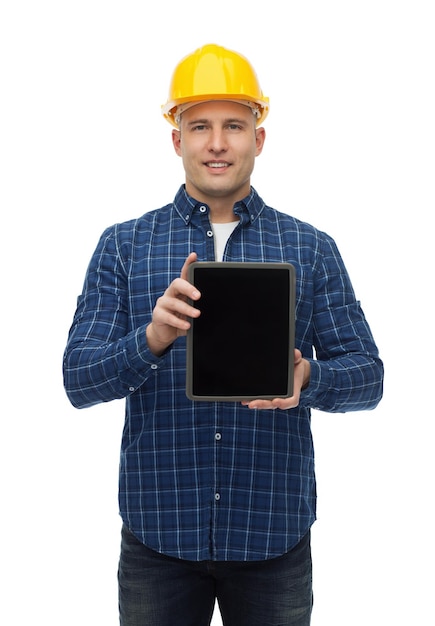 concepto de reparación, construcción, construcción, personas y mantenimiento - constructor masculino sonriente o trabajador manual en casco que muestra la pantalla en blanco de la computadora de tablet pc