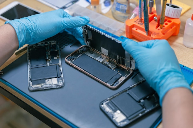 Foto concepto de reparación de teléfonos un teléfono móvil ensamblado por el reparador en el escritorio