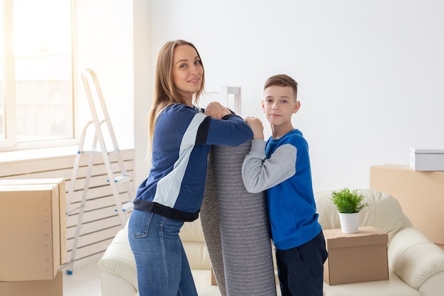 Concepto de reubicación, inauguración de la casa y bienes raíces: una madre soltera sonriente y un hijo encantador son