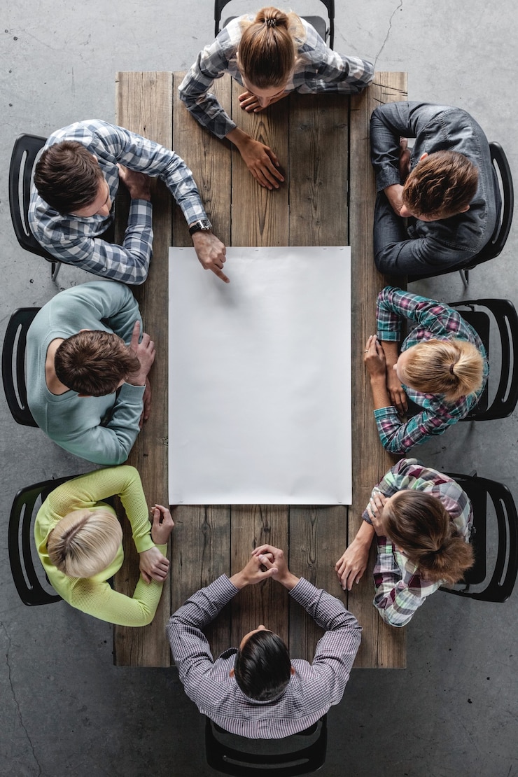 Foto concepto de reunión de planificación de lluvia de ideas de trabajo en equipo de negocios hipster, personas sentadas alrededor de la mesa con papel blanco