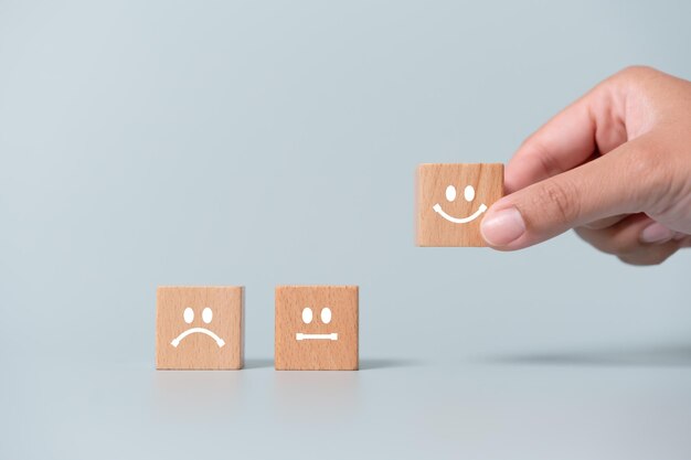 Concepto de revisión de satisfacción del cliente bloques de madera con expresión facial