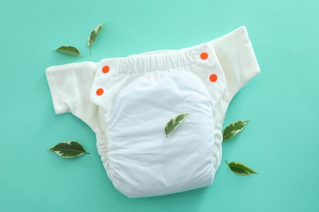 Concepto de ropa de bebé con pañales reutilizables sobre fondo de menta