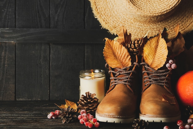 Concepto de ropa de otoño con botas y hojas sobre fondo de madera