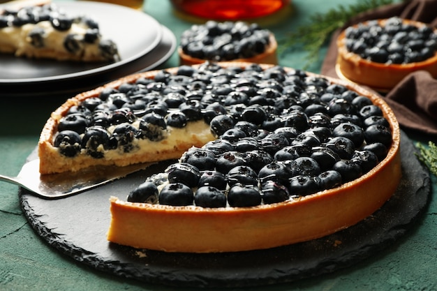 Concepto de sabroso almuerzo con tarta de arándanos en verde