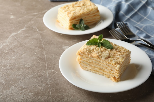 Concepto de sabroso almuerzo con tarta de Napoleón en mesa gris