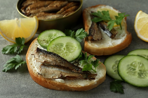 Concepto de sabroso bocadillo con sándwiches con espadines sobre fondo de textura gris