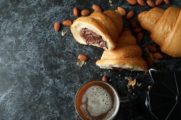 Concepto de sabroso desayuno con croissant con chocolate en la oscuridad