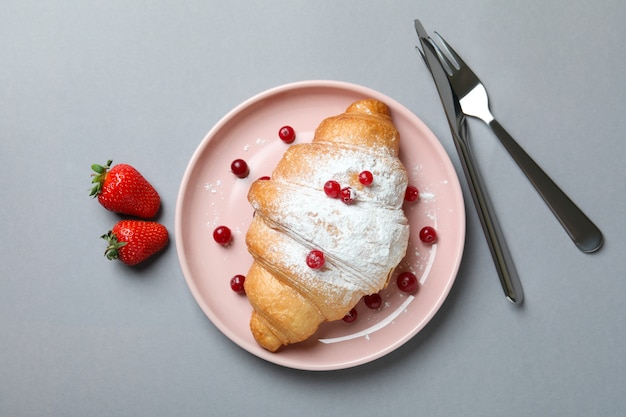 Concepto de sabroso desayuno con croissant en gris