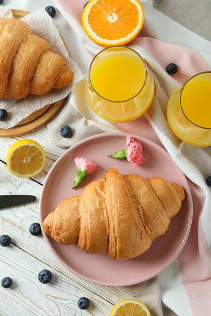 Concepto de sabroso desayuno con croissants en madera blanca