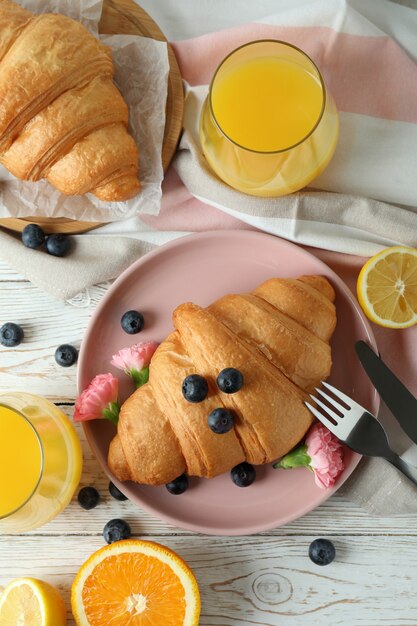 Concepto de sabroso desayuno con croissants en madera blanca