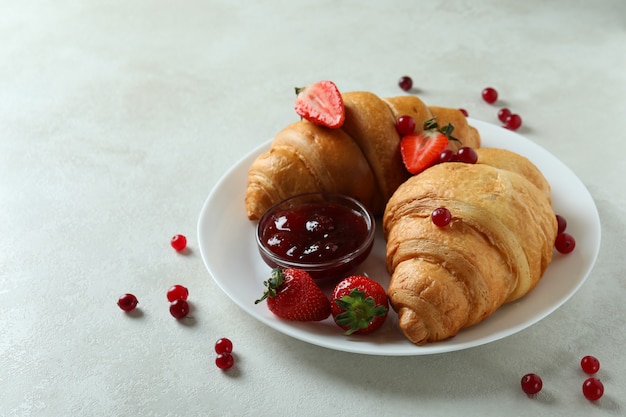 Concepto de sabroso desayuno con croissants en mesa con textura blanca