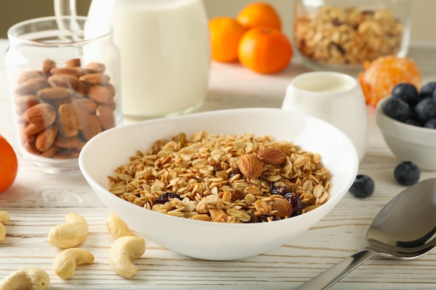 Concepto de sabroso desayuno con granola sobre fondo de madera