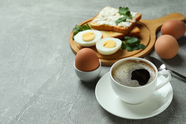 Concepto de sabroso desayuno con huevos duros en mesa con textura gris