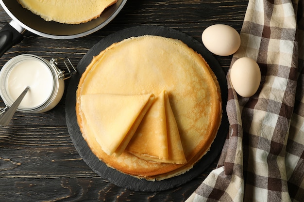 Concepto de sabroso desayuno con tortitas finas en mesa de madera