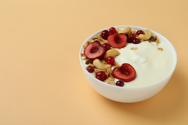 Concepto de sabroso desayuno con yogur sobre fondo beige