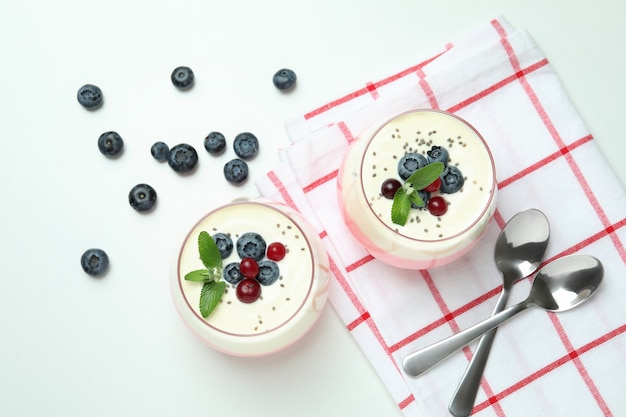 Concepto de sabroso desayuno con yogur sobre fondo blanco.