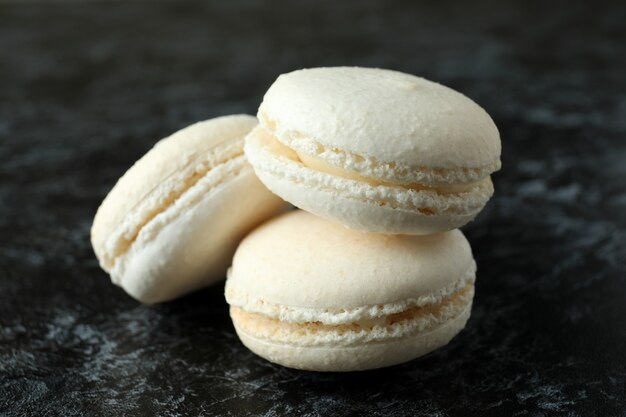 Concepto de sabroso postre con macarrones sobre fondo negro ahumado