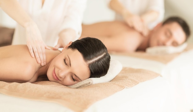 concepto de salud y belleza - imagen de una pareja en un salón de spa recibiendo un masaje