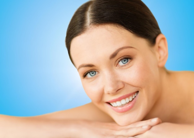 Foto concepto de salud y belleza, resort y relajación - hermosa mujer sonriente en el salón de spa acostado en la mesa de masajes