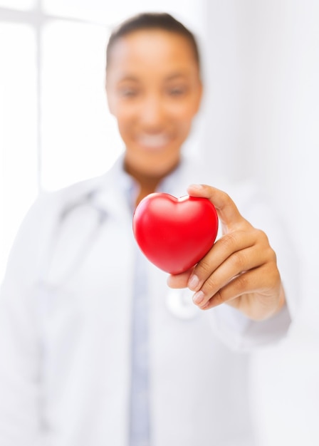 Foto concepto de salud y caridad - cerca de la mano de la mujer sosteniendo el corazón