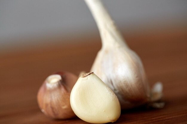 concepto de salud, comida, cocina, medicina tradicional y etnociencia - cierre del ajo en la mesa de madera