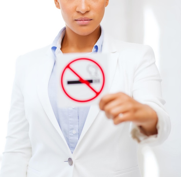 Foto concepto de salud y cuidado de la salud: imagen de mujer africana con señal de prohibición de fumar